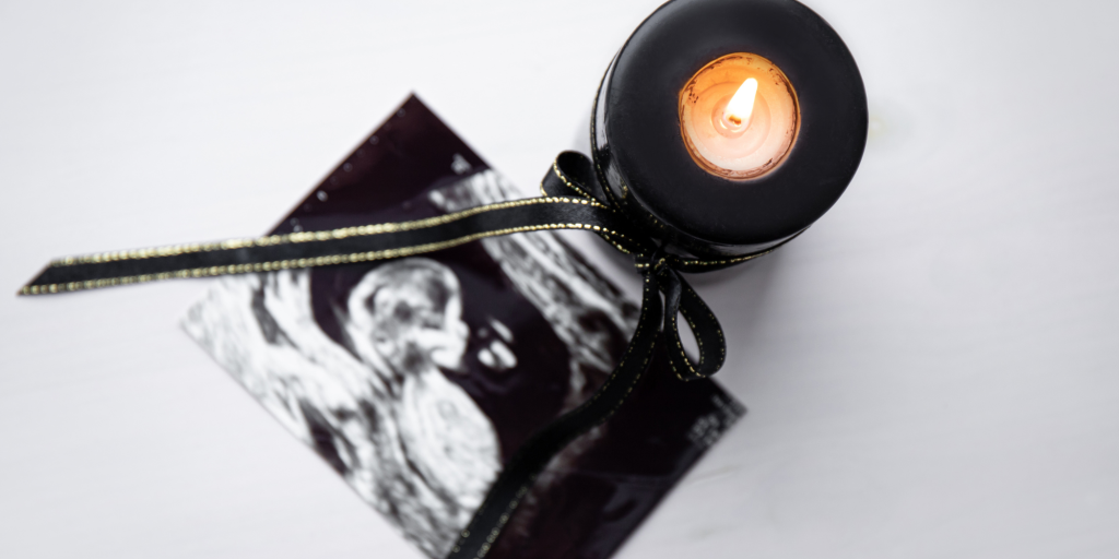 black candle with ultrasound honoring those who have lost a pregnancy or infant